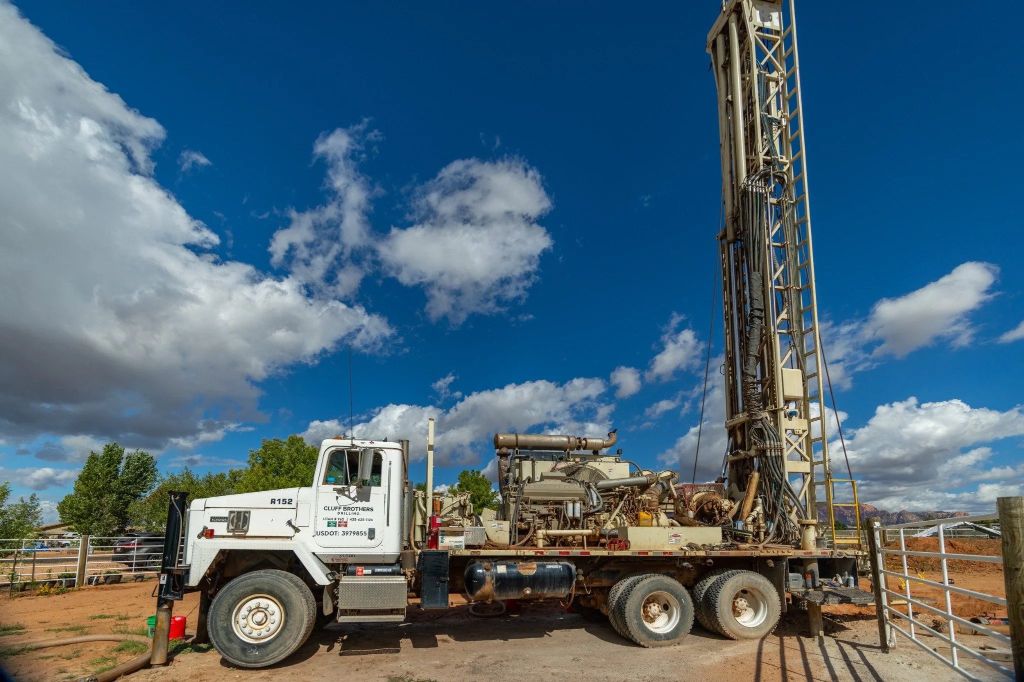 Cluff Brothers Drilling truck with its mast raised at a dirt jobsite