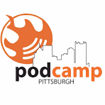 Logo for PodCamp Pittsburgh with an orange podcast microphone and city skyline. Alicia Avsargolu | Speaker | Pittsburgh Podcamp | Fractional Digital Chief of Staff | Digital Transformation