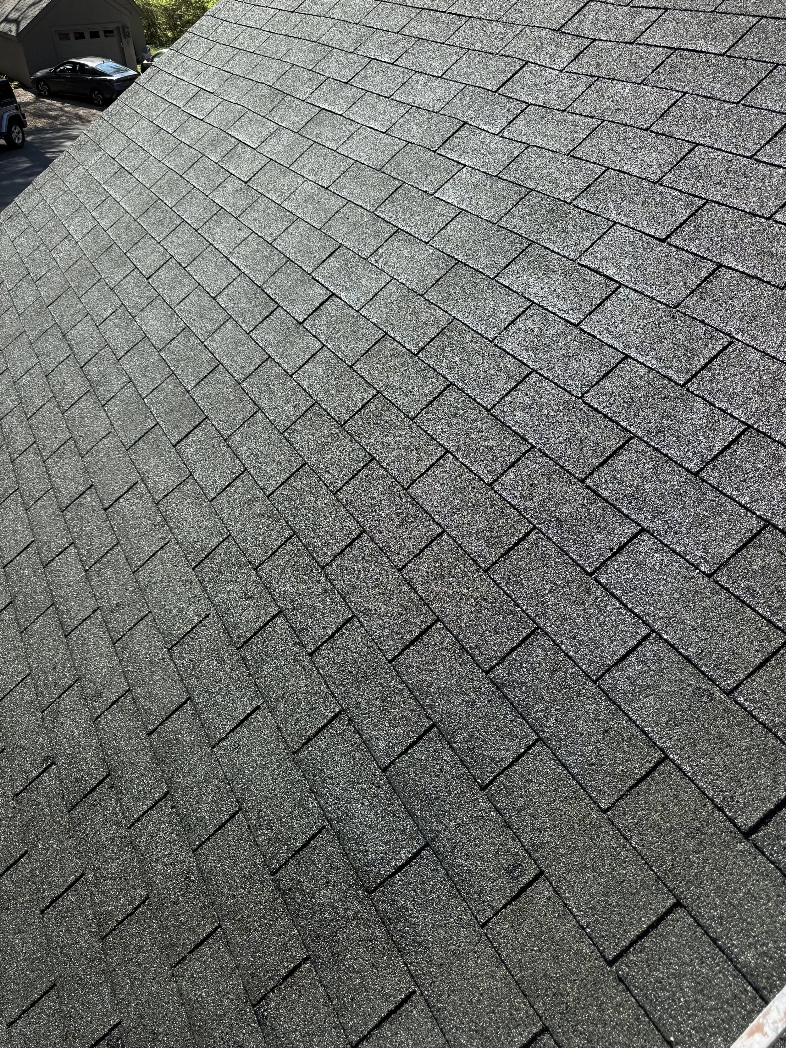 Close-up view of a black asphalt shingle roof with evenly aligned rectangular shingles.