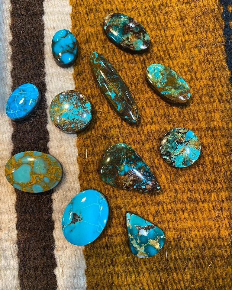 Collection of turquoise stones on a textured fabric background.