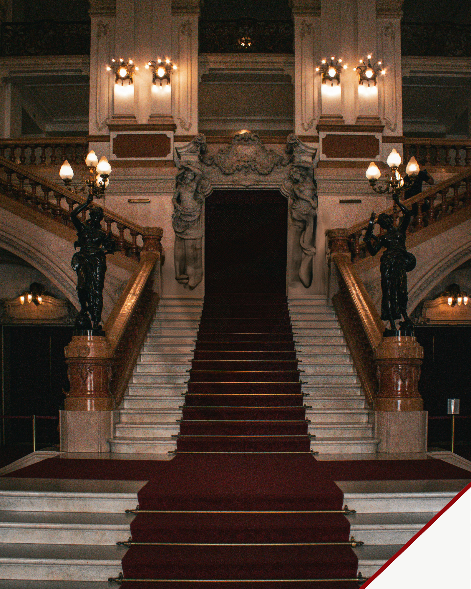 Explore Places — grand marble staircase with a red carpet, ornate balustrades and warm decorative lighting.