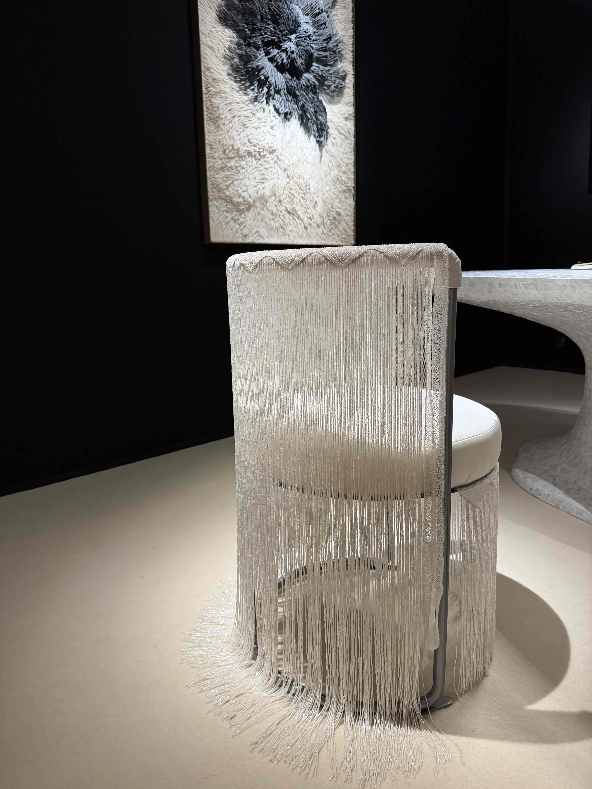 Sculptural white fringed chair displayed among collectible design at PAD London.