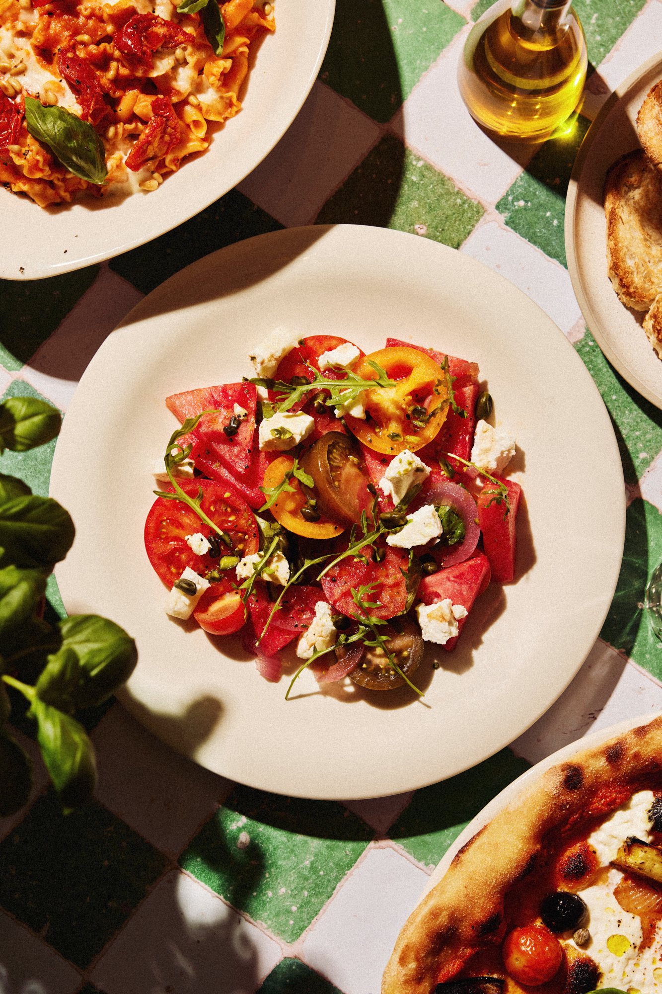 Overhead photograph of a colourful Italian salad with watermelon and cheese.