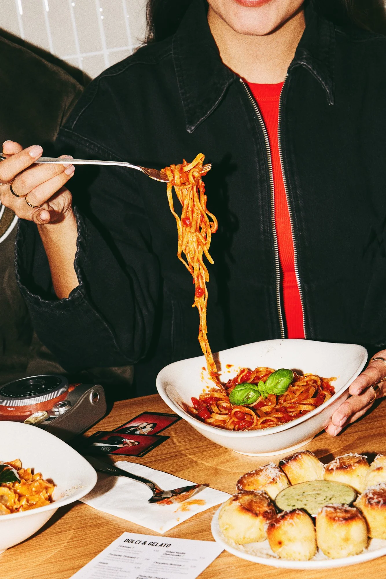 Diner lifting spaghetti from a bowl of pasta at an Italian restaurant.
