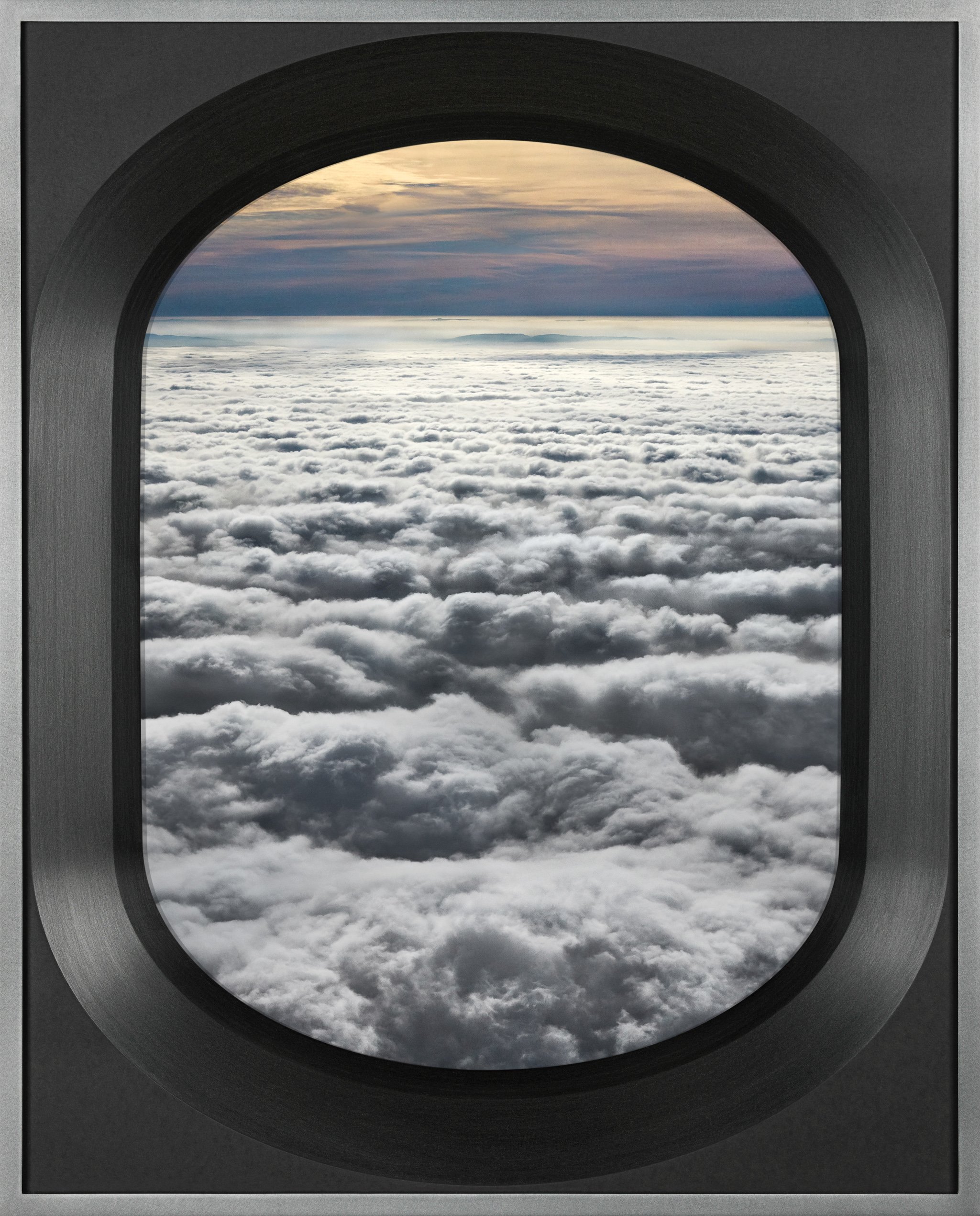View of clouds and sky through an airplane window.