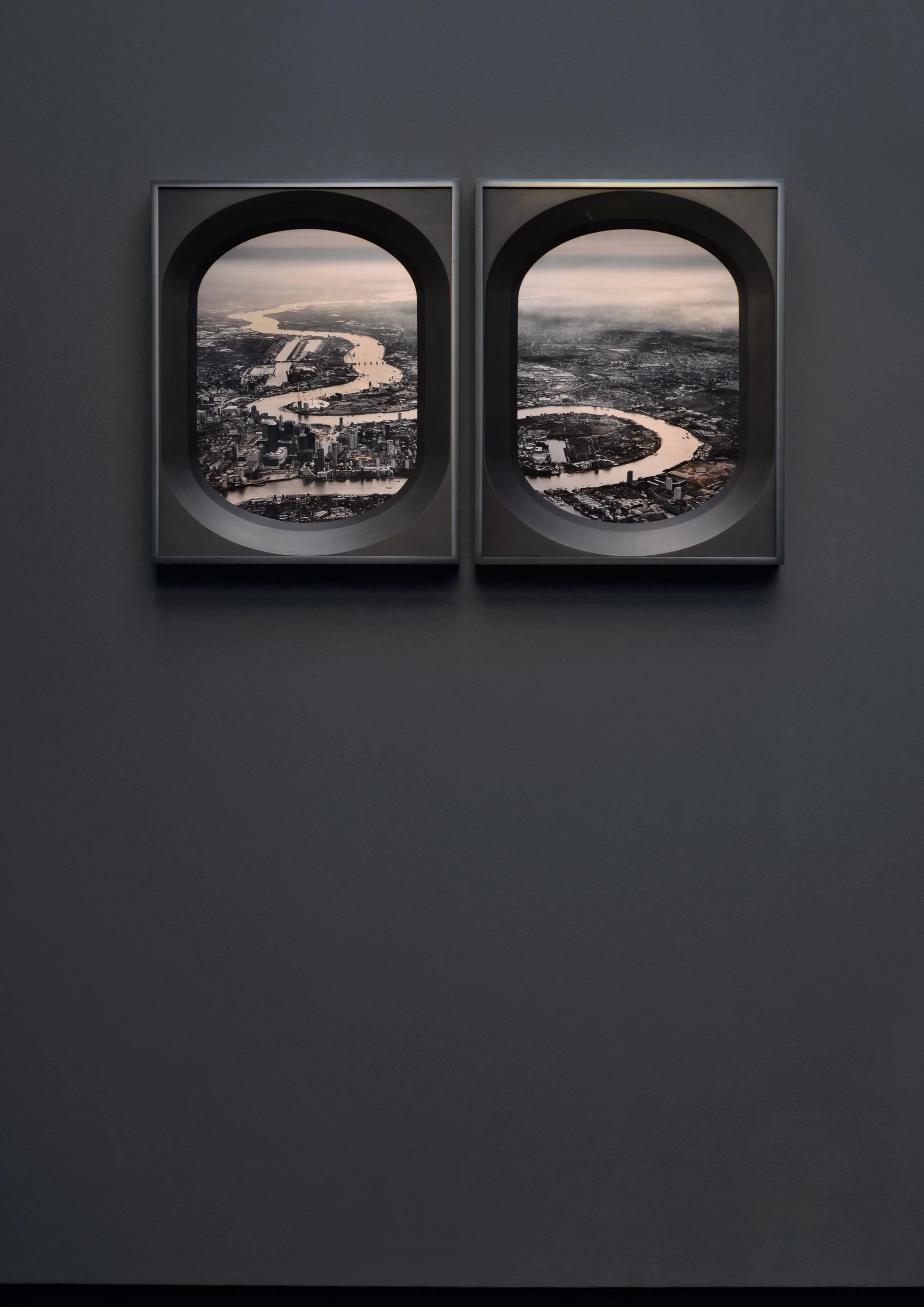 View of a cityscape with a river, seen through airplane window frames.