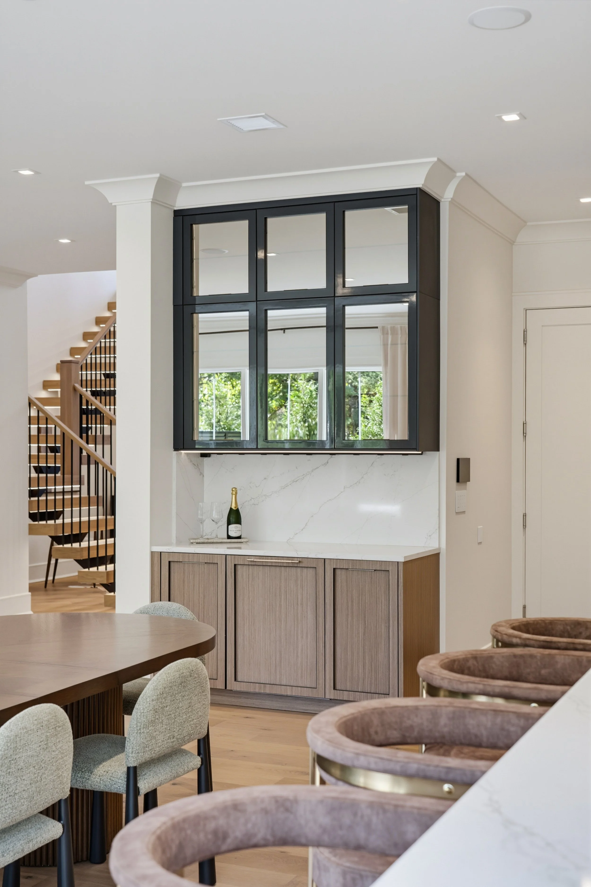 Monarch palette dining area with wet bar, glass-front cabinets and open staircase