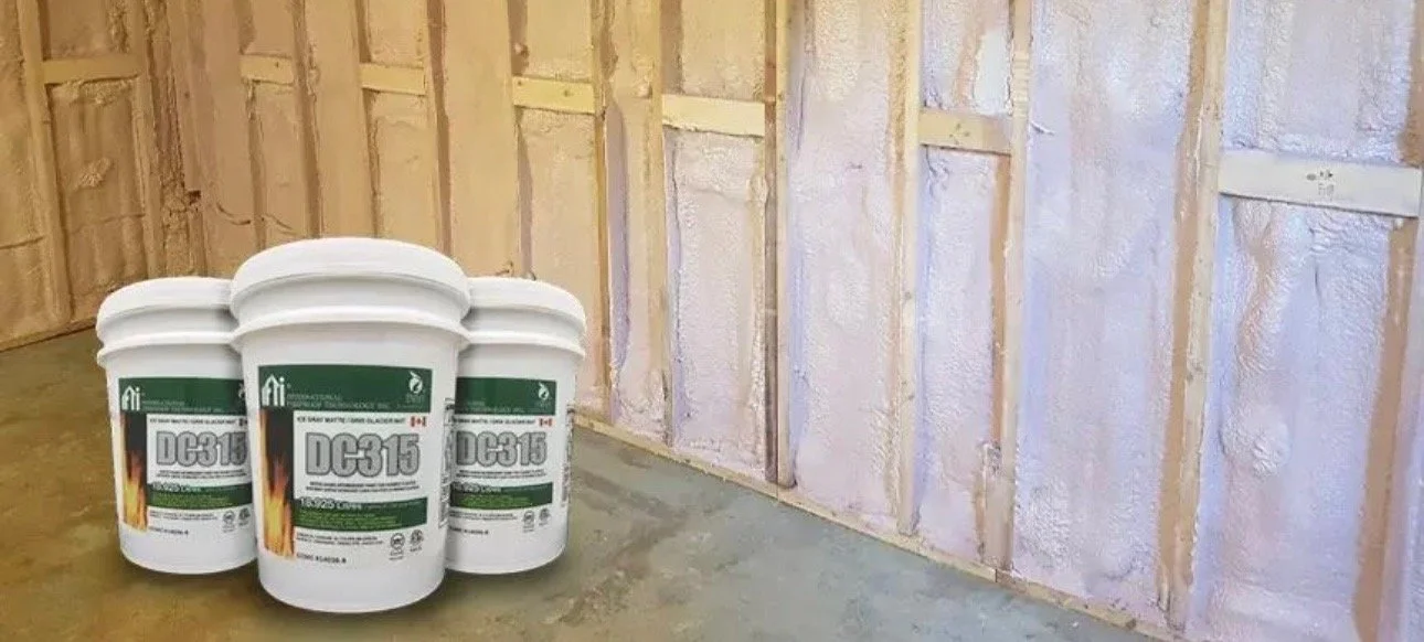 Four buckets of old-fashioned spray foam insulation placed on the floor inside a room with exposed wall studs.