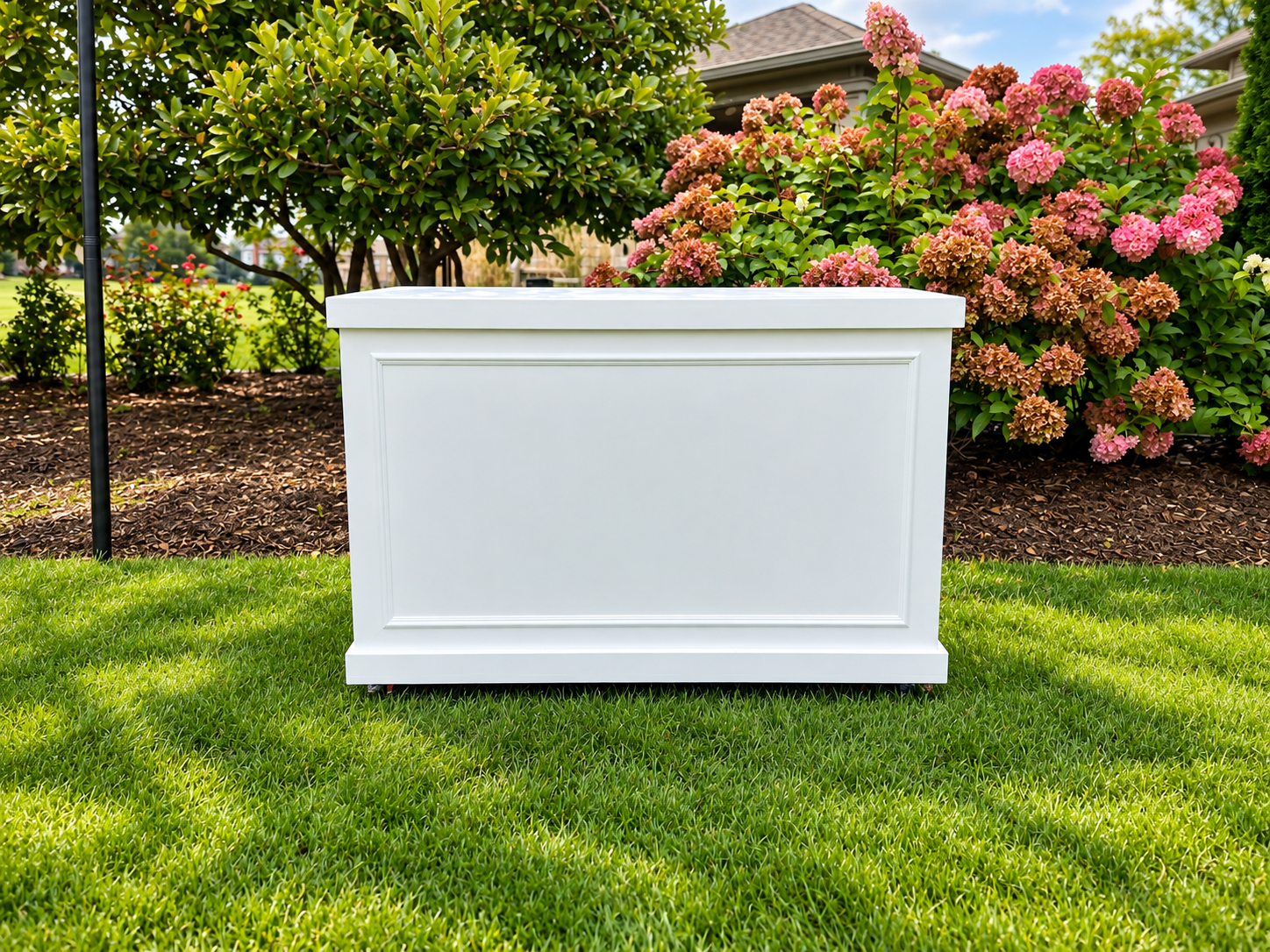 White Paneled Planter in Blooming Garden.png