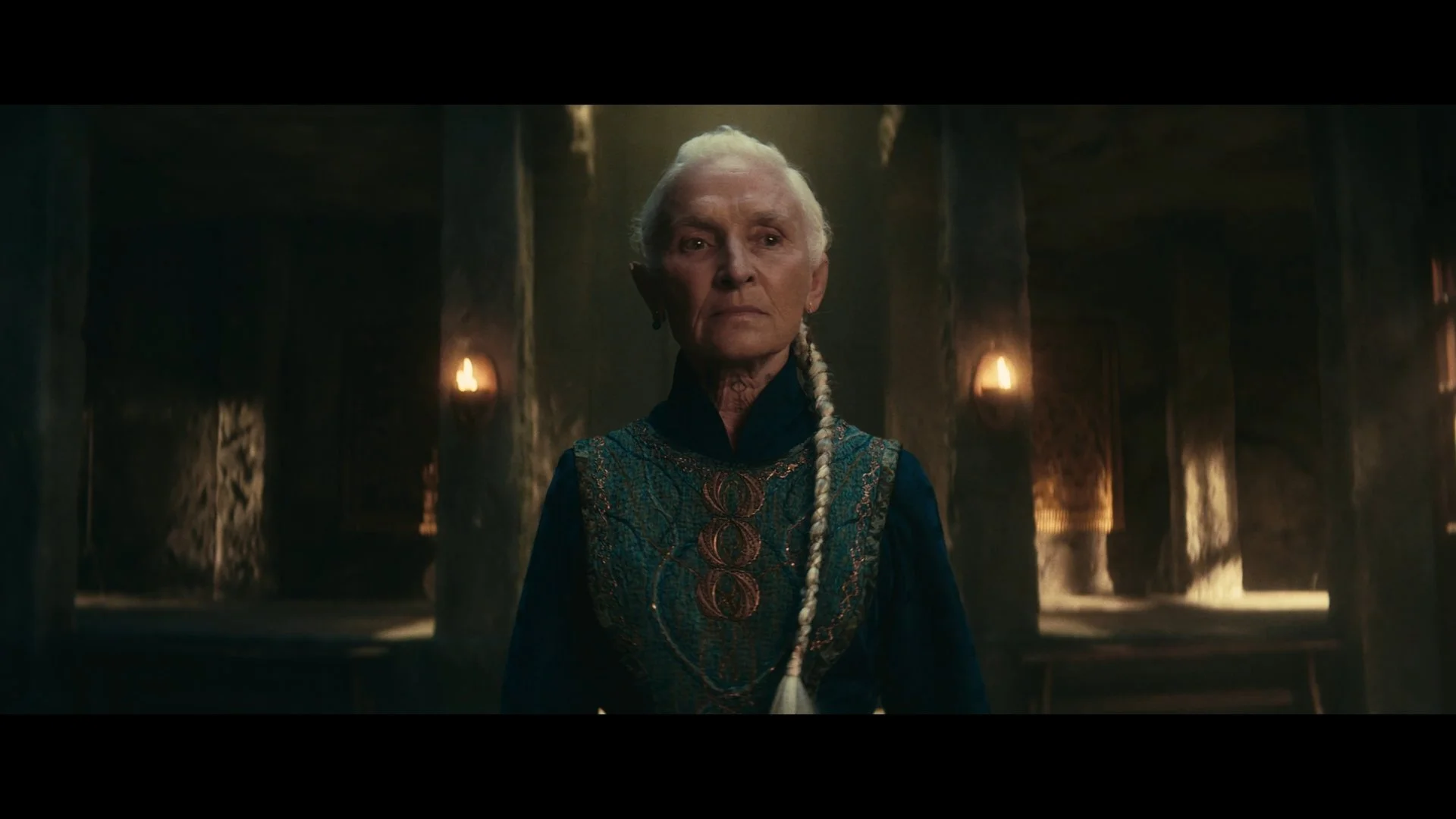 Still from Wayfinders, featuring a man with long white braided hair in a candlelit stone room, shot by director of photography Shamus Whiting-Hewlett.