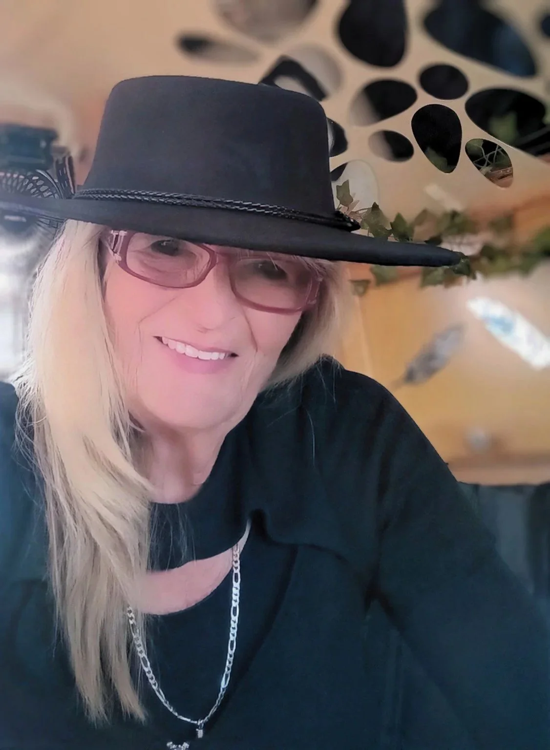 Jo smiling in a black hat inside her T@B camper