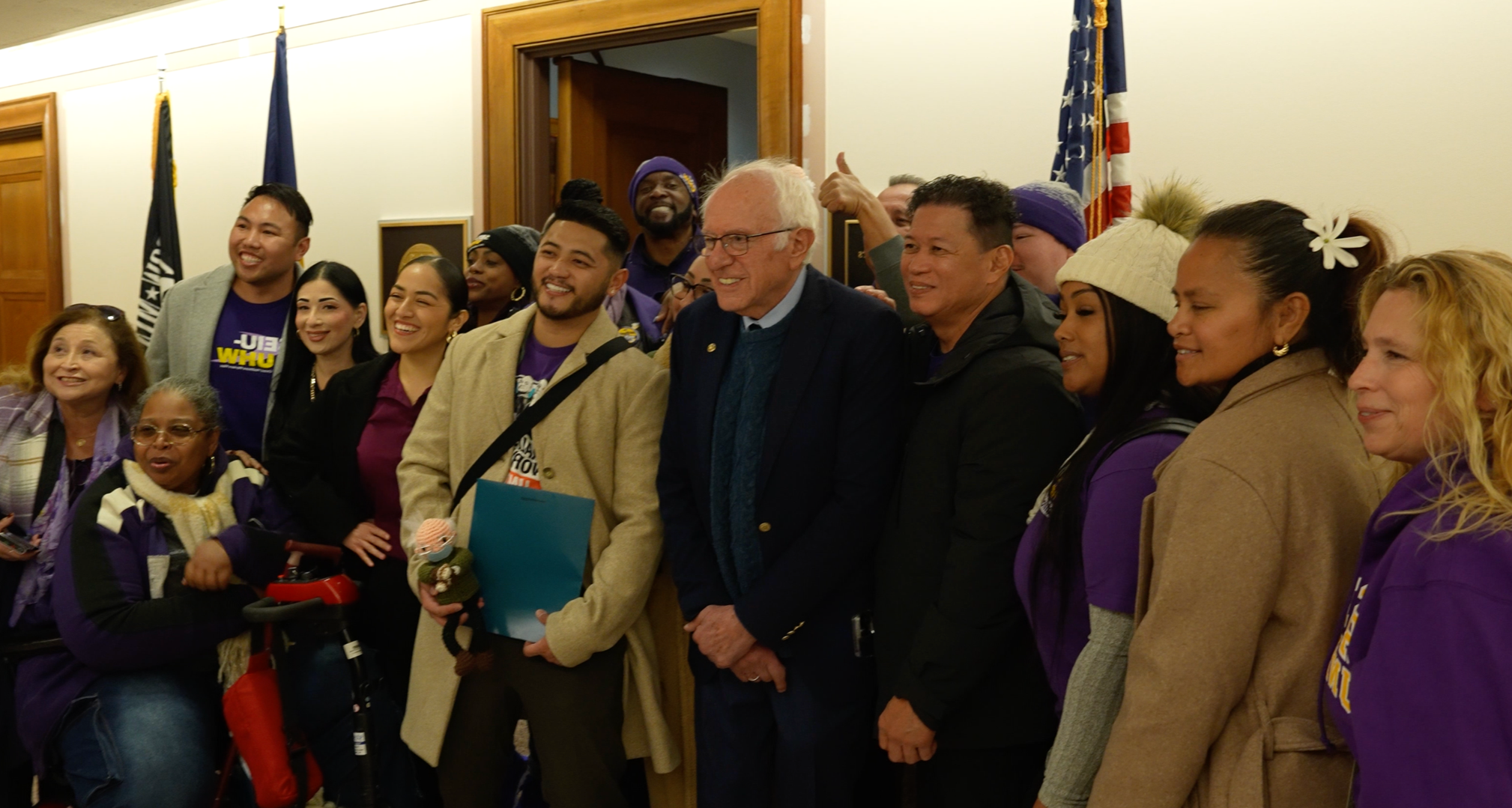Senator Bernie Sanders posing with a large group of union healthcare workers.