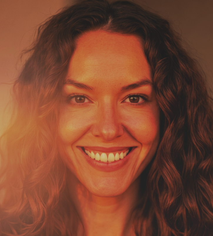 Close-up of a smiling woman with curly brown hair.