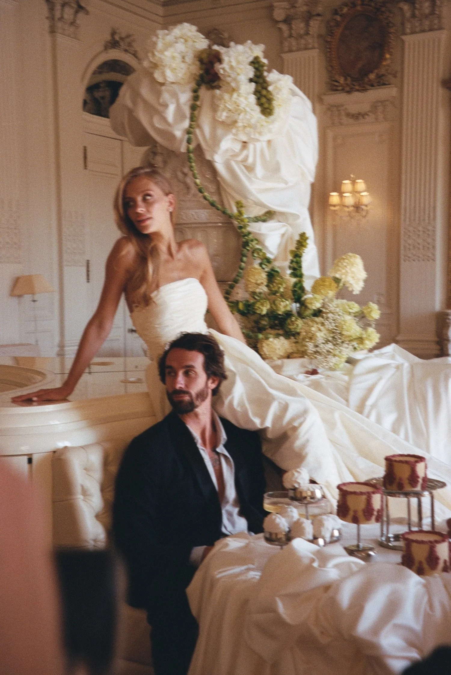 Des mariés lors de leur mariage dans une salle élégante de chateau de Ferrières, décorée de fleurs blanches et d'une ambiance chaleureuse.