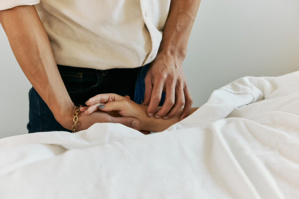 Person comforting a sick or injured person lying in bed