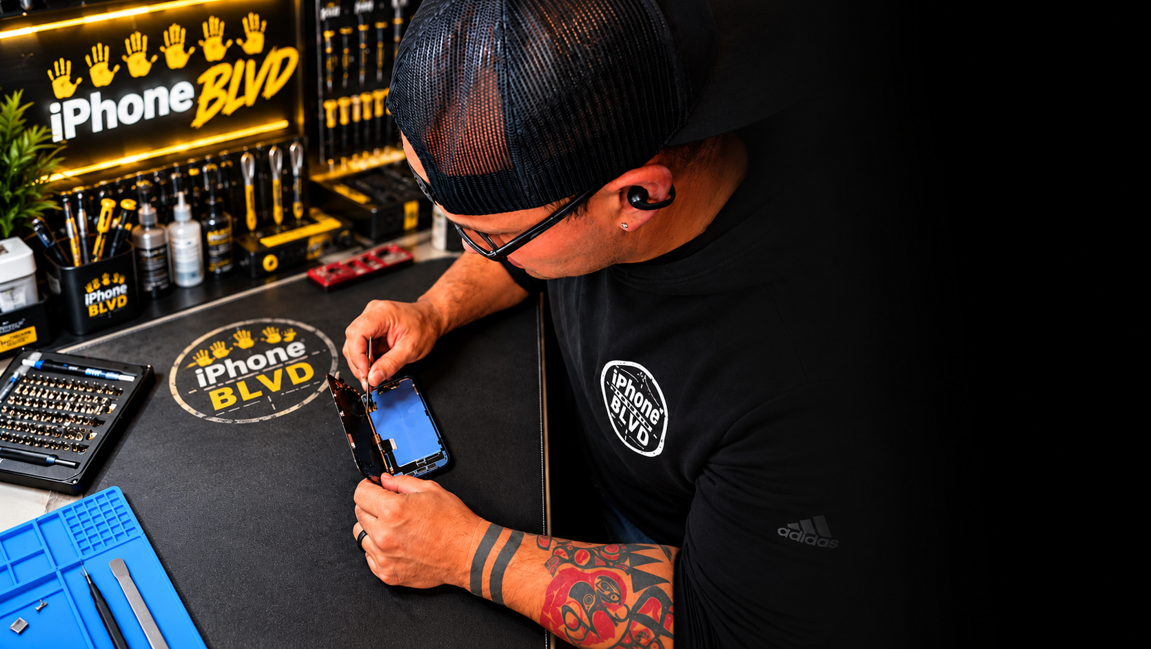 Joe, lead technician at iPhone BLVD in Kennewick, WA, repairing an iPhone at his workbench. Expert iPhone repair serving Kennewick, Pasco, Richland, and the Tri-Cities since 2004.