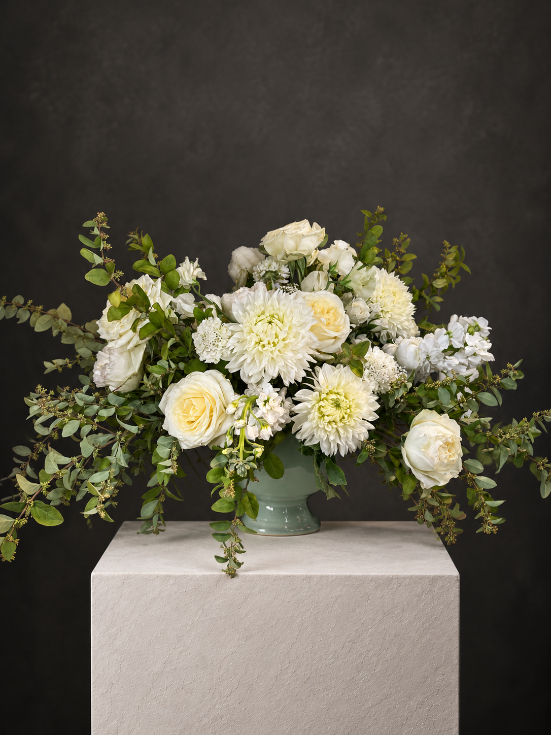Elegant Cream Floral Arrangement on Stone Plinth.png