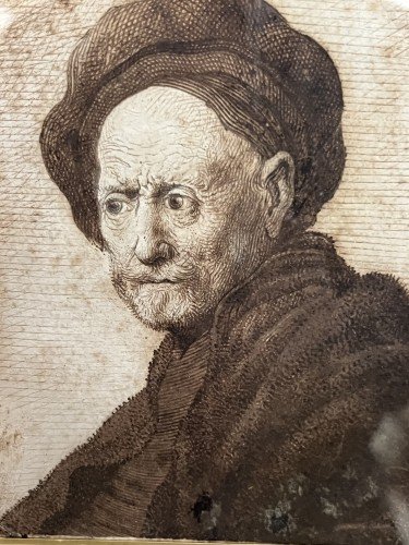 A pen and ink drawing by Rembrandt showing an old man in a hat.