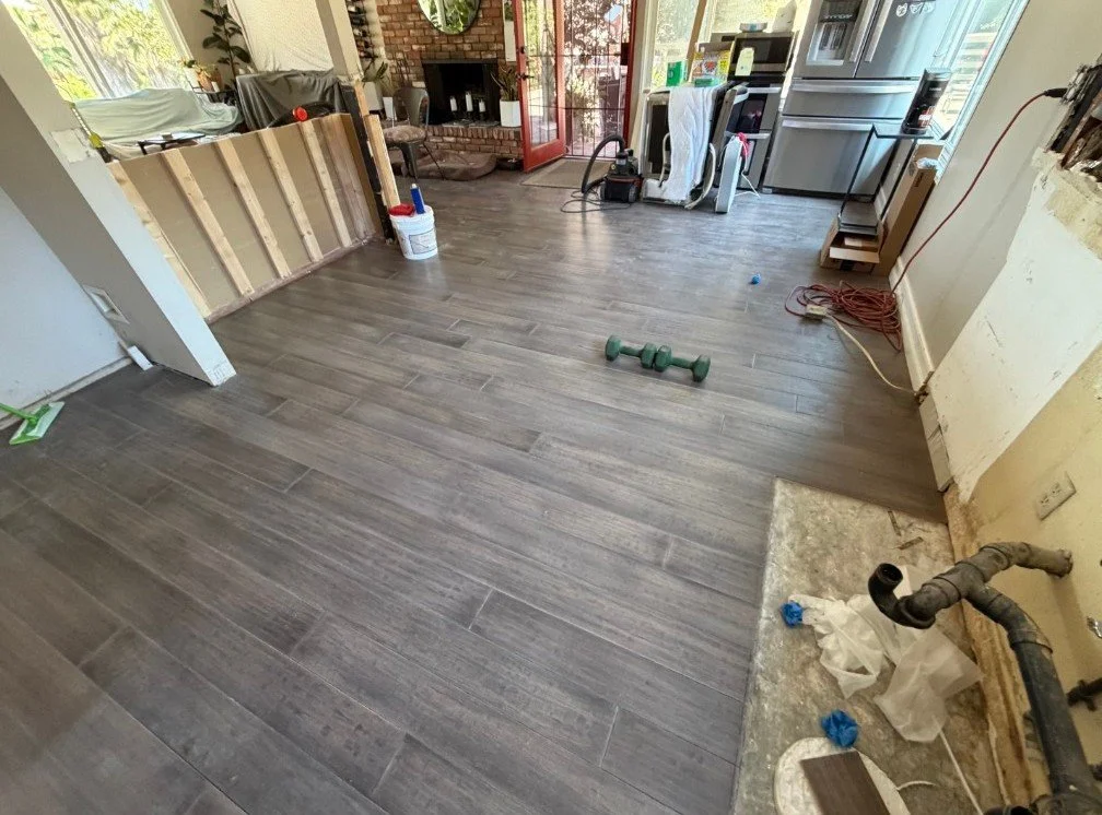 Floor repair after wall removal — after. Matching material blends the repaired area into the existing floor.