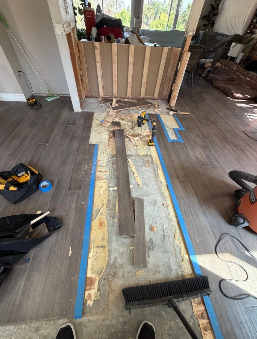 Floor repair after wall removal — before. The customer removed a wall, leaving a gap in the flooring.