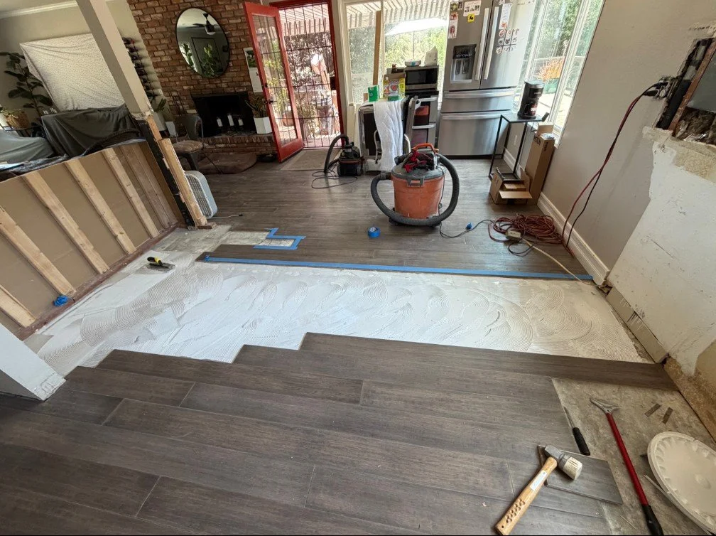 Floor repair after wall removal — in progress. We sourced matching material and patched the gap.