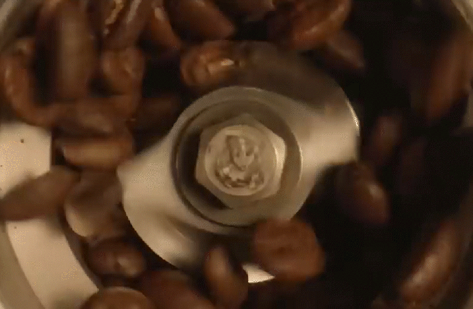 Close-up of a metal bolt and nut surrounded by brown pebbles