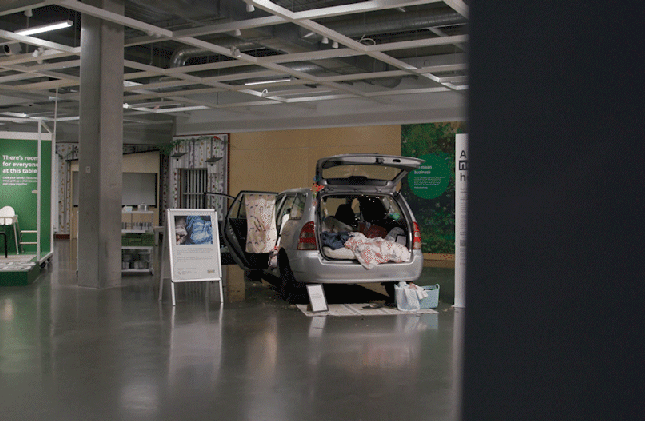SUV display with open doors and trunk inside a modern showroom