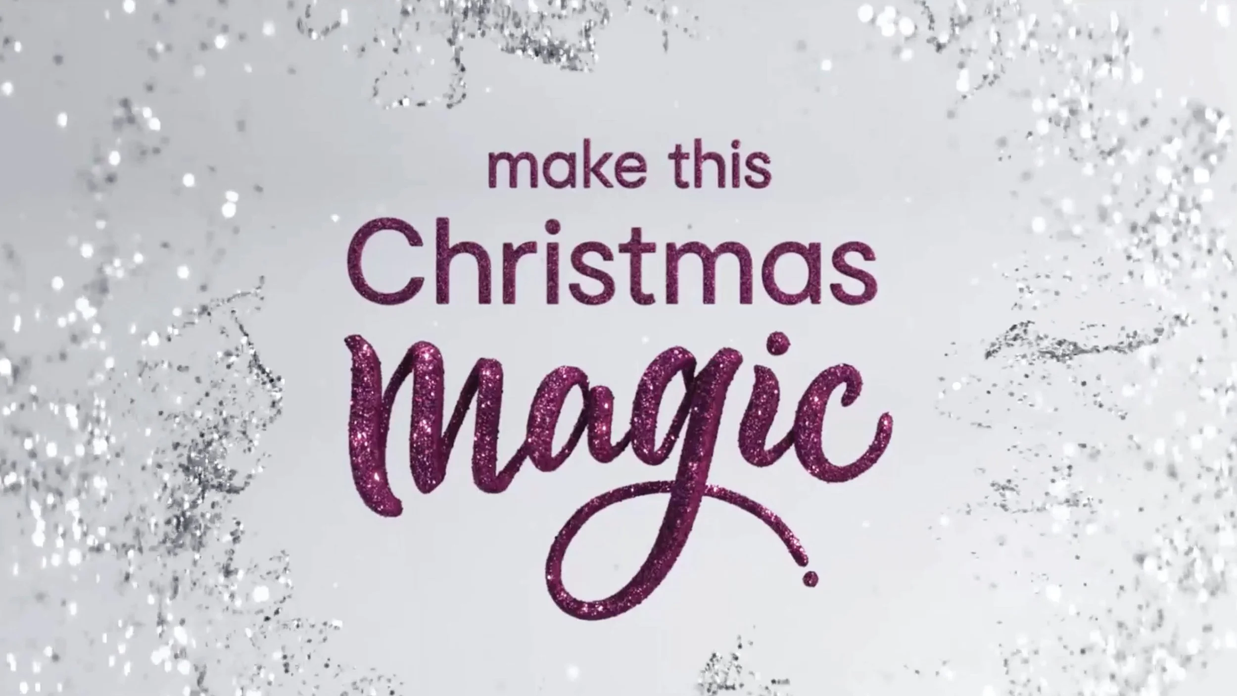 Glittery holiday card reading “Make This Christmas Magical” in purple lettering on a silver glitter background