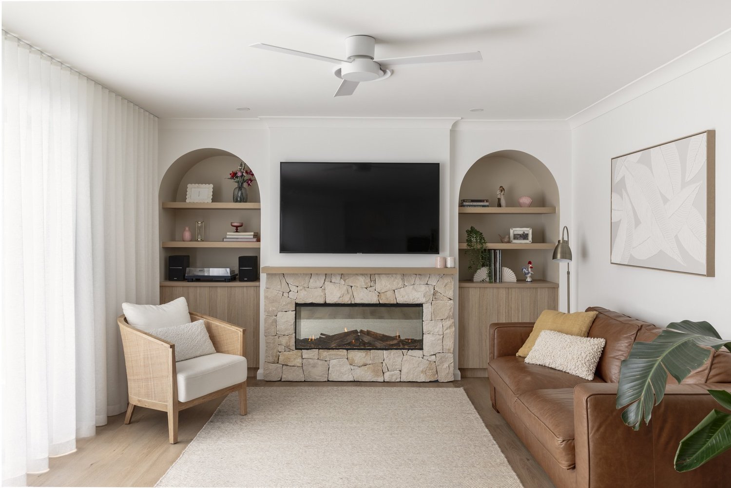 Living room with sandstone fireplace and arched timber shelving, Albion Park home renovation