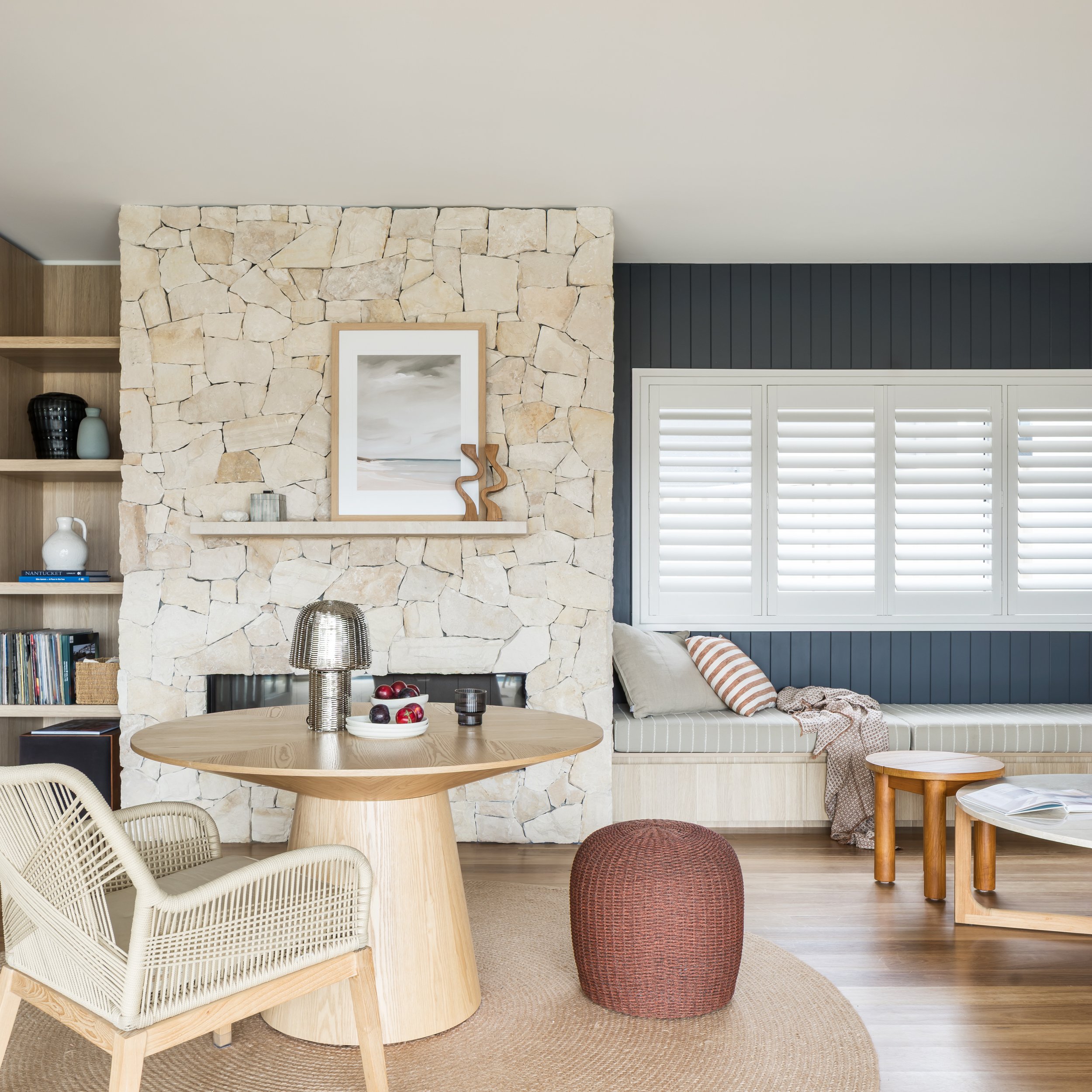 Natural stone fireplace with navy panelled window seat, Shell Cove