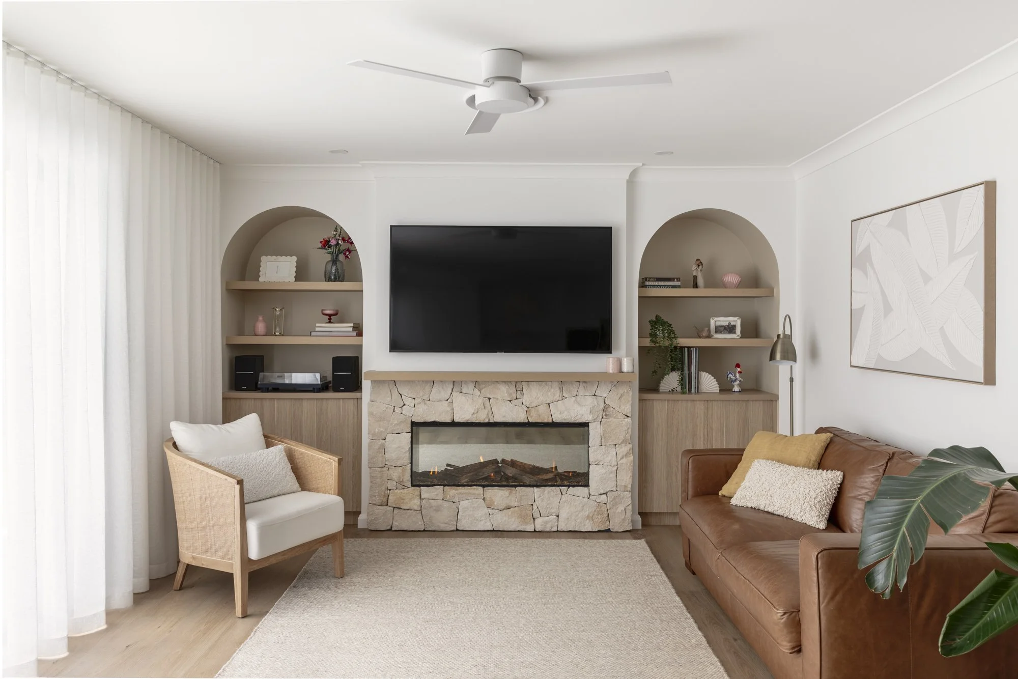 Eco Outdoor sandstone fireplace between arched alcoves with timber shelving, Albion Park