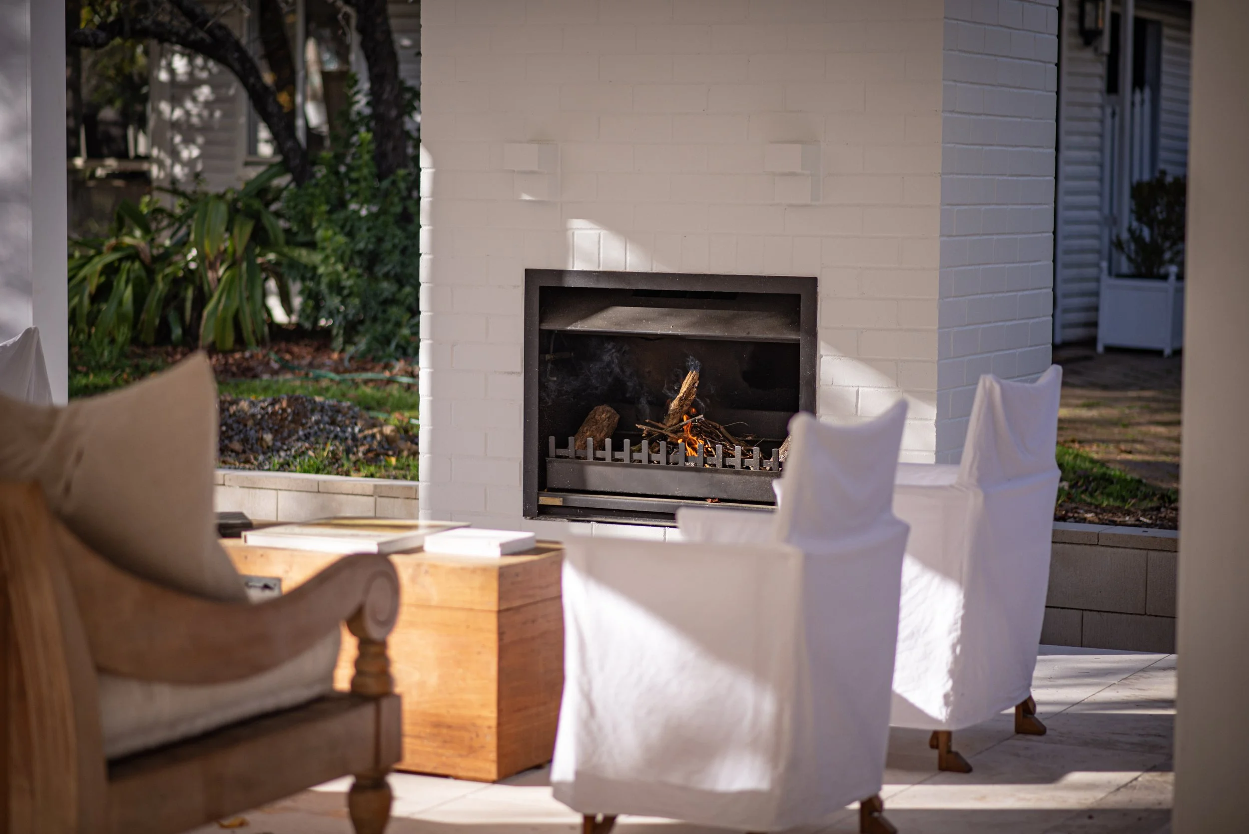 Wood burning fireplace in a painted brick chimney, Canyonleigh outdoor living