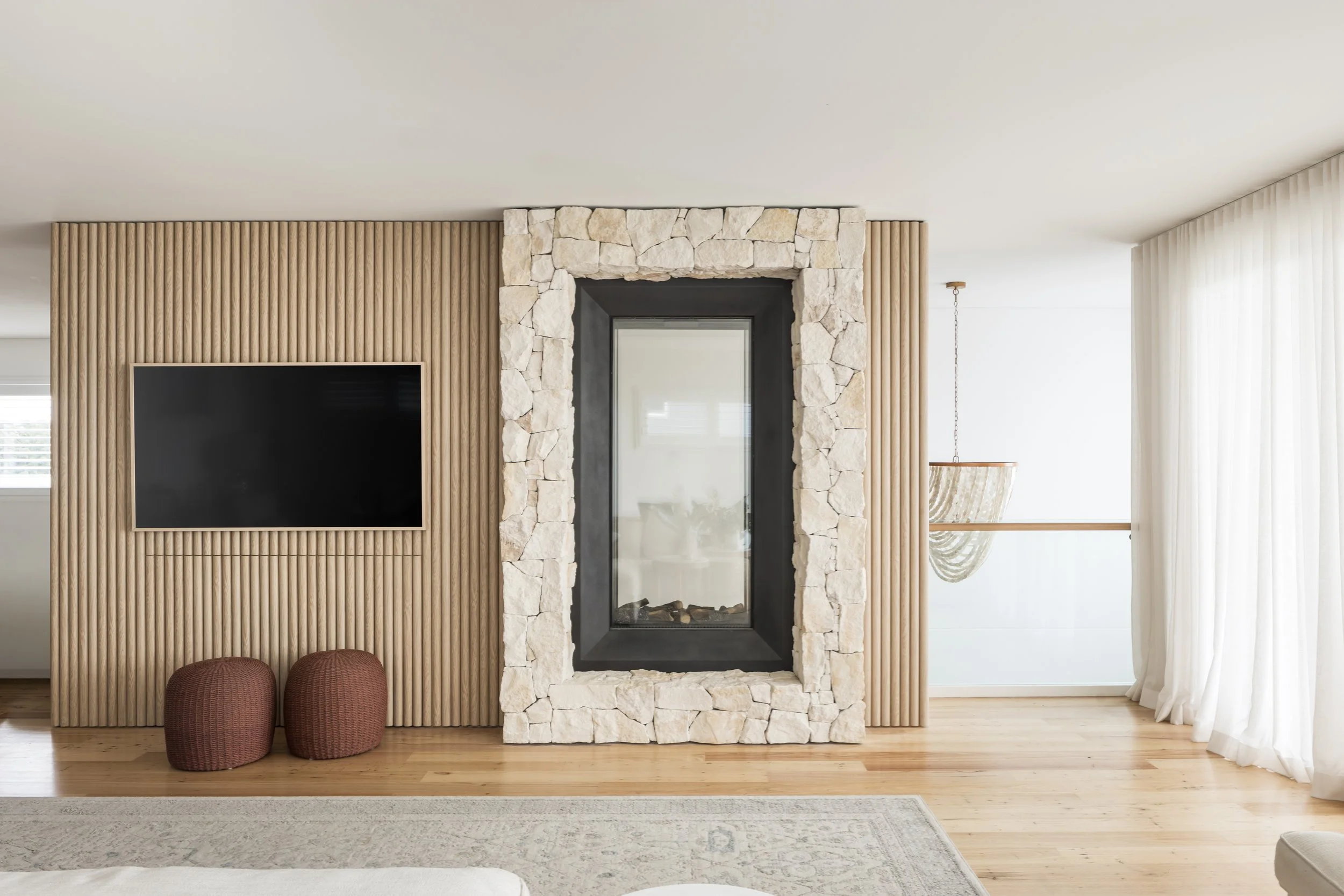 Fluted timber wall with double sided stone fireplace, Shell Cove home renovation