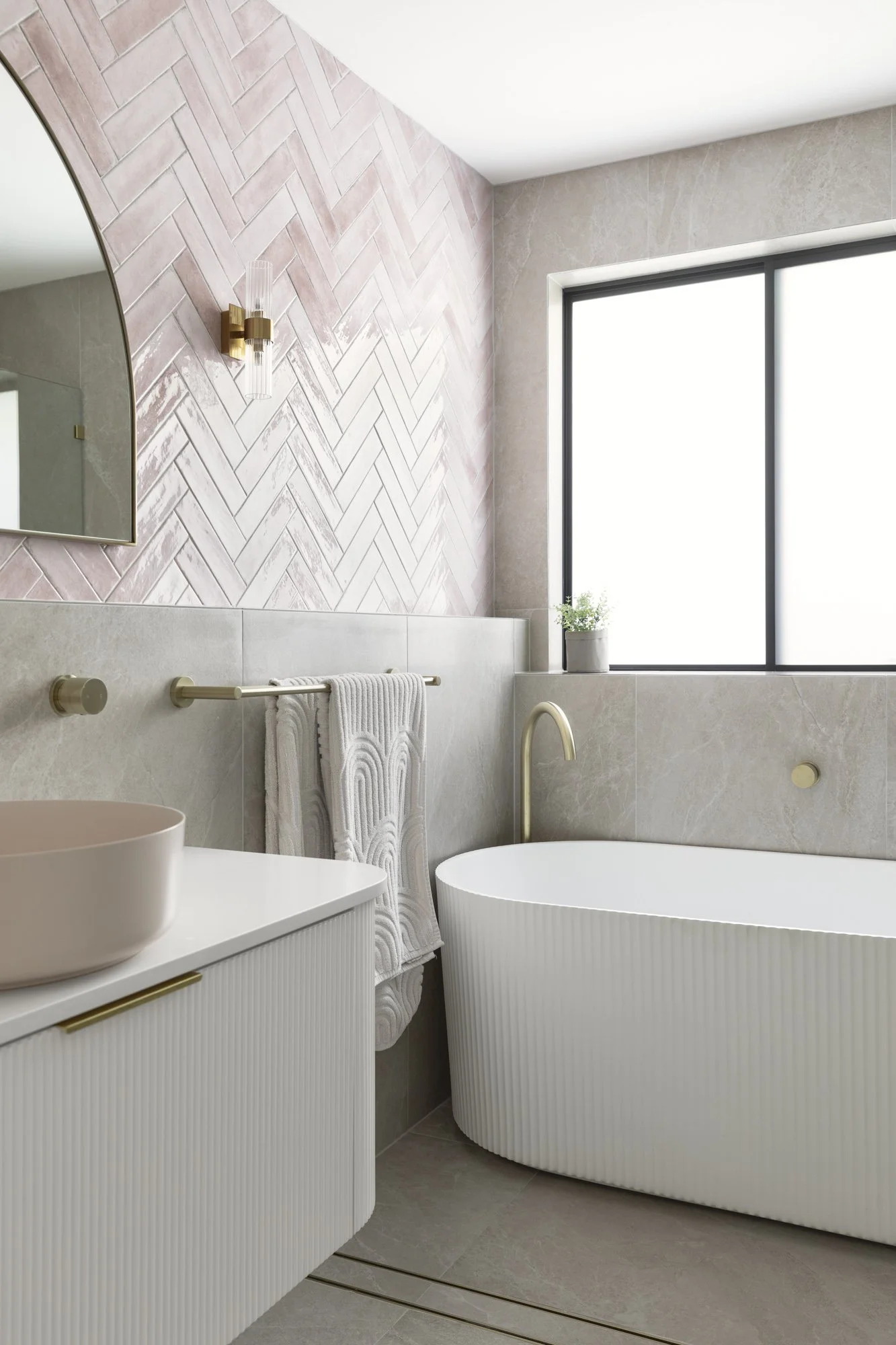 Pink herringbone tiled bathroom with fluted freestanding bath, Albion Park