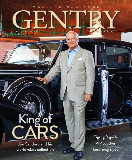 Magazine cover featuring an older man in a light-colored suit standing next to a vintage black car with the title "GENTRY" at the top, indicating it's a Western New York publication. The cover text highlights Jim Sandoro as the "King of Cars" and mentions topics like a cigar gift guide, VIP pooches, and local mug clubs.