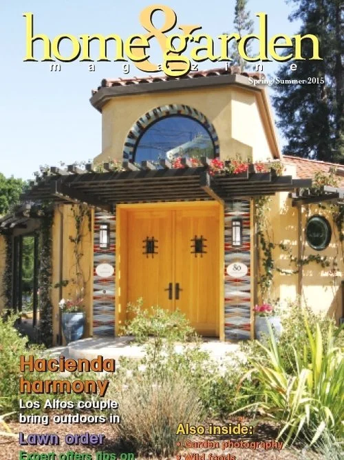 Cover of Home & Garden Magazine, Spring/Summer 2015, featuring a Spanish-style house with a yellow door, rounded window above, and garden decor.