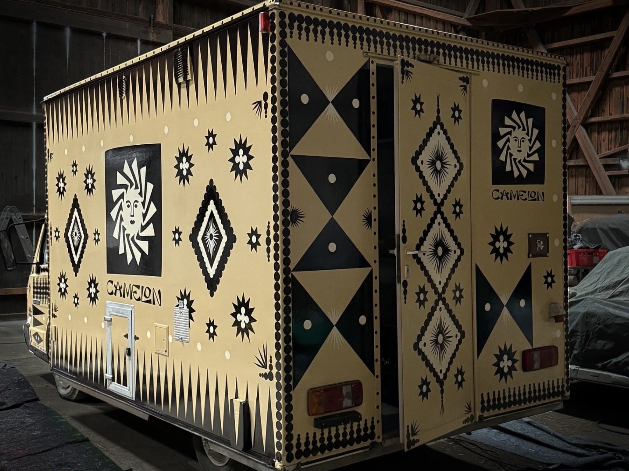 Ein Foodtruck mit schwarzem, weißen Tribal-Muster, mit dem Markennamen 'Camelon'.