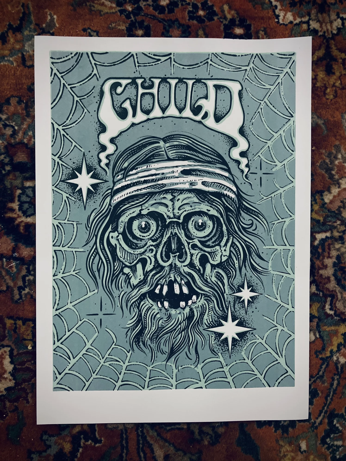 Illustration eines gruseligen, bärtigen Skulls mit Spinnennetz-Hintergrund, Sternen und dem Schriftzug „CHILD“.