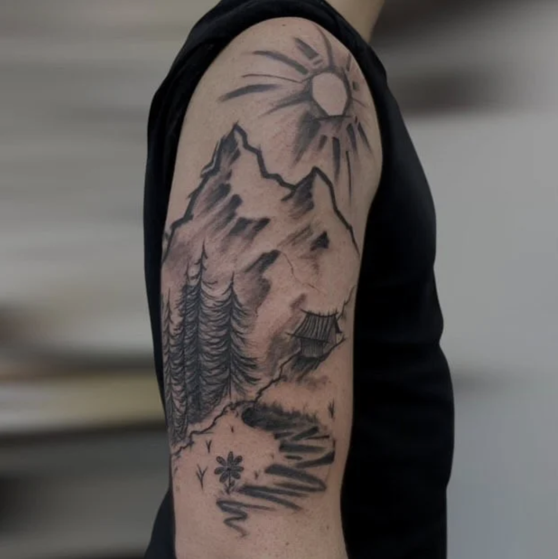 Illustrative Berglandschaft als Tattoo auf Oberarm