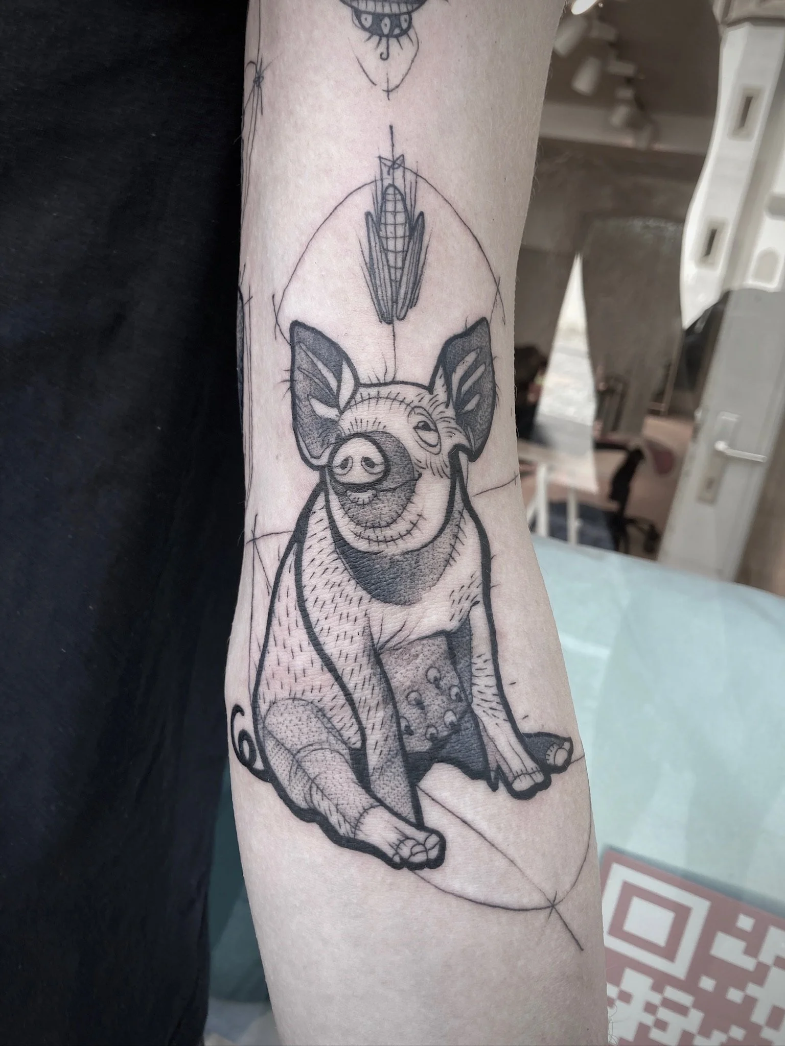 Schwarz-graues Tattoo eines sitzenden Schweins