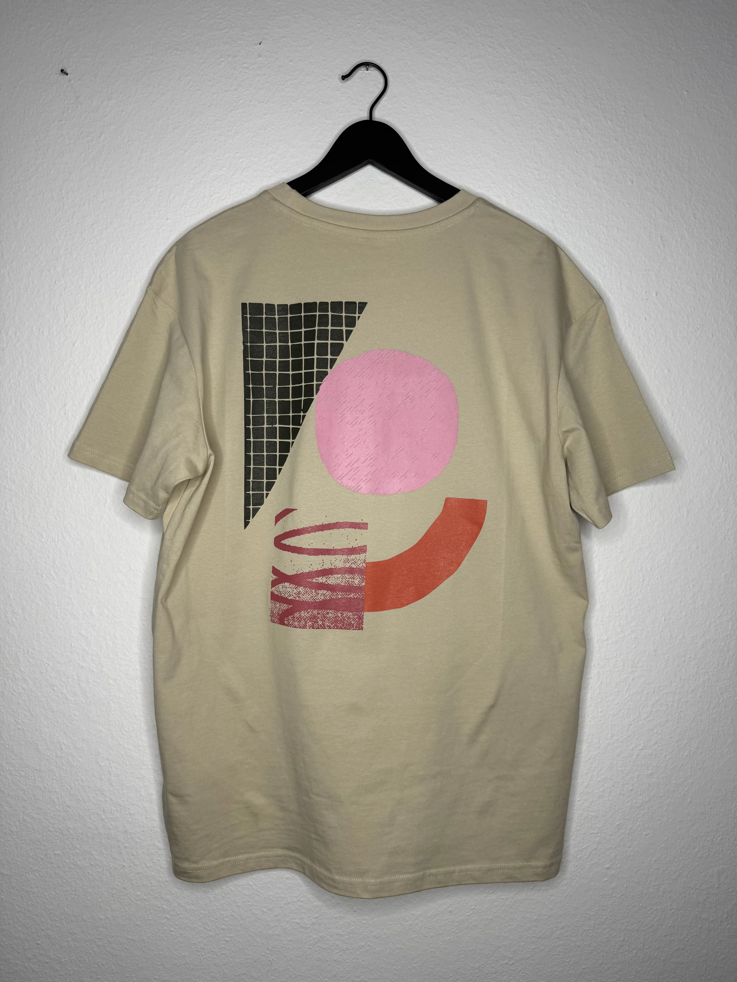 Beigefarbenes T-Shirt mit abstraktem geometrischem Backprint auf schwarzem Kleiderbügel