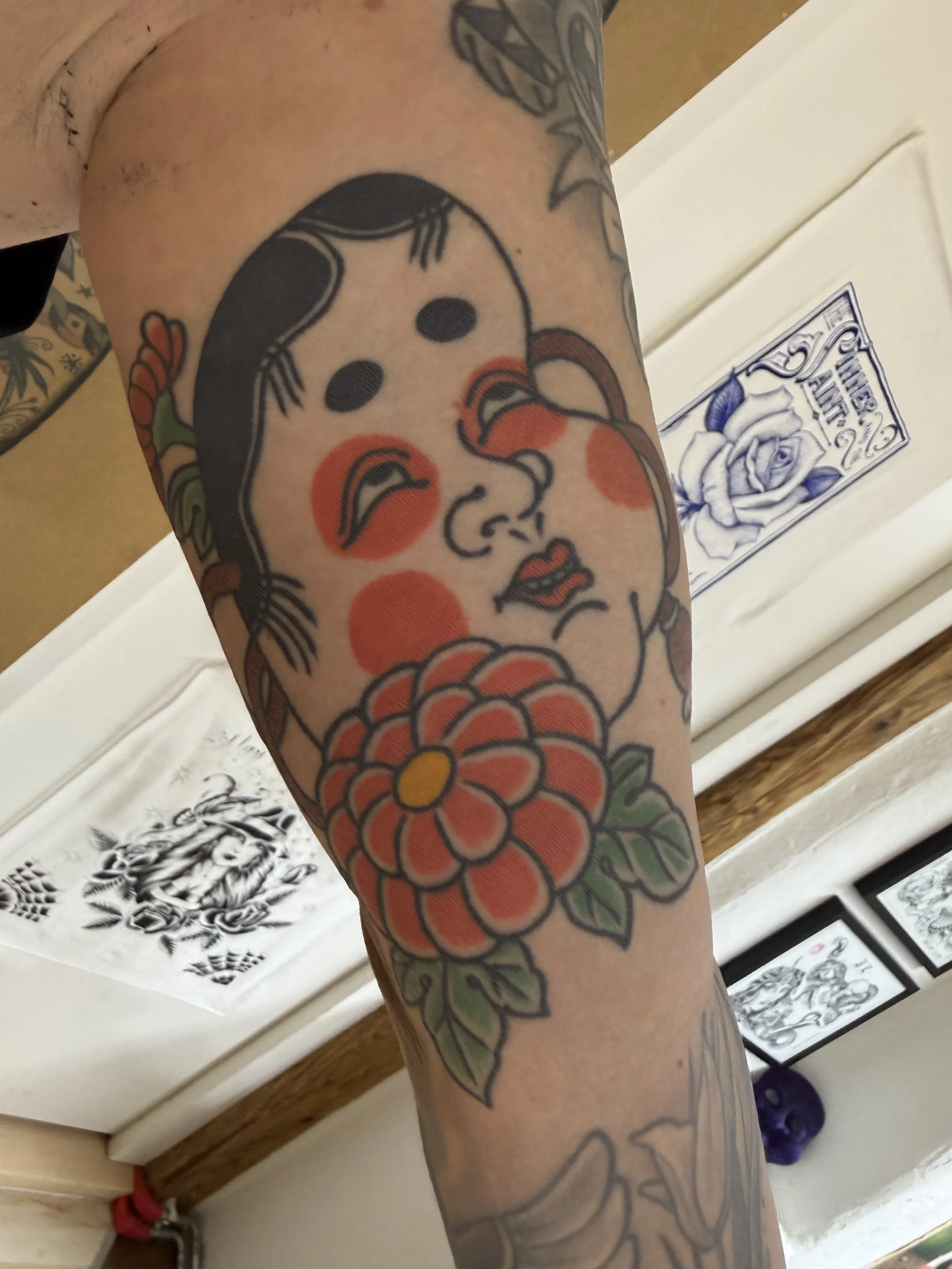 Nahaufnahme eines tätowierten Arms mit einem farbigen traditionellen japanischen Masken Tattoos und Chrysantheme
