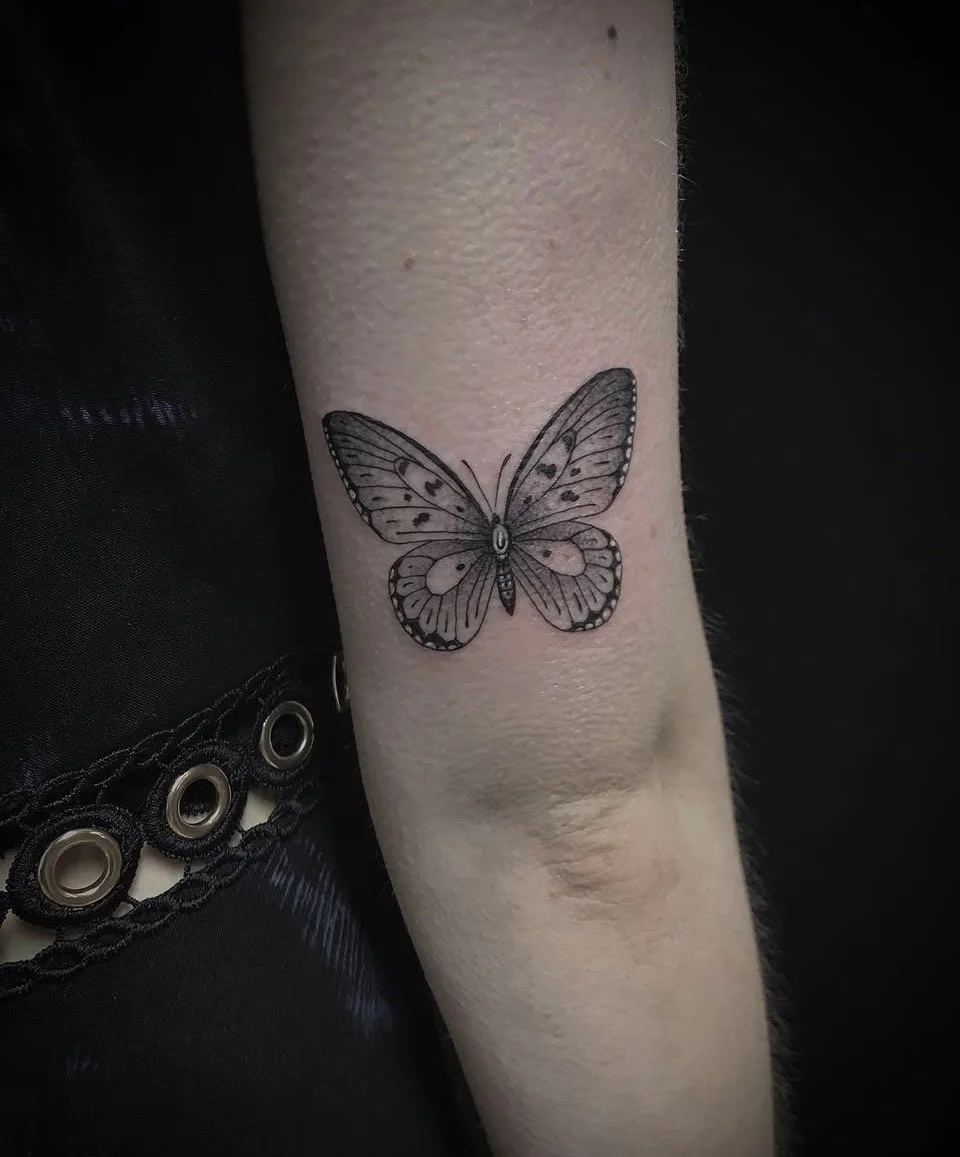 Nahaufnahme eines fein detaillierten Schmetterling-Tattoos auf einem Unterarm
