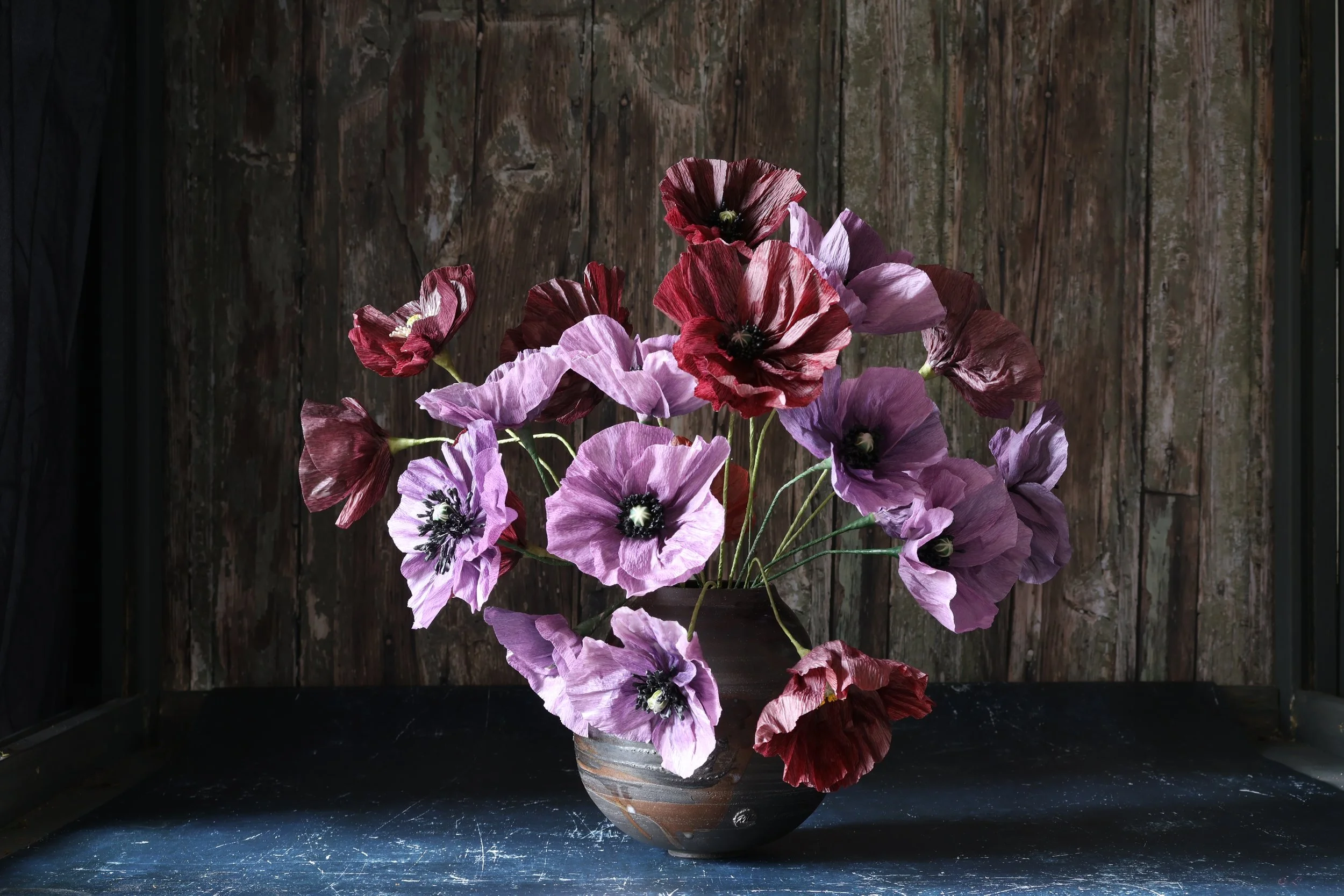Dark Purple Icelandic Poppies in a dark vase and rustic background