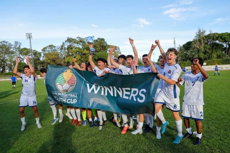 Youth soccer team celebrating with a trophy and Winners banner after winning the Byron Football Youth Cup