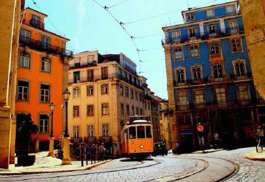 Orange tram traveling along curved tracks through a historic European city street lined with colorful buildings