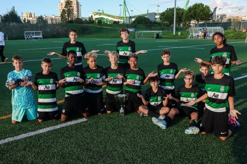 Youth soccer team posing with a trophy on an outdoor artificial turf field