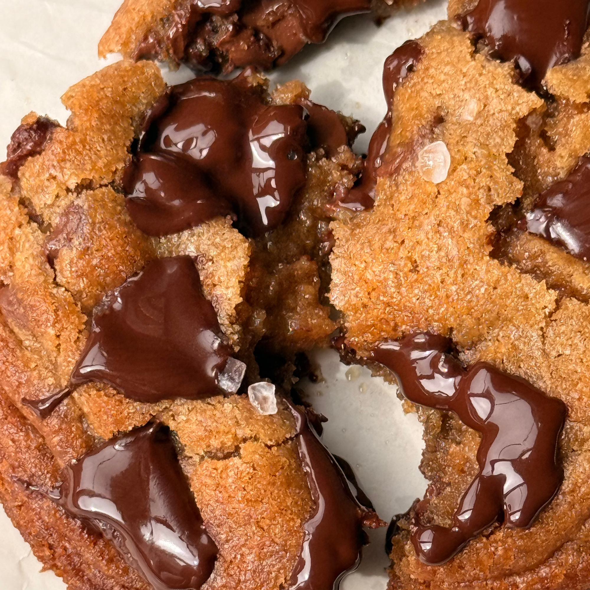 Close-up of a dessert featuring two slices of carrot cake topped with chocolate glaze and chocolate sauce drizzle.