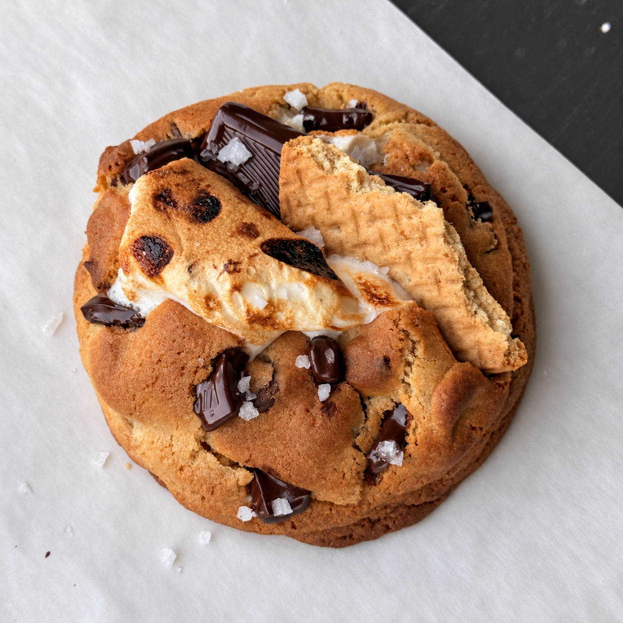 Warmly lit s'mores cookie on parchment.png