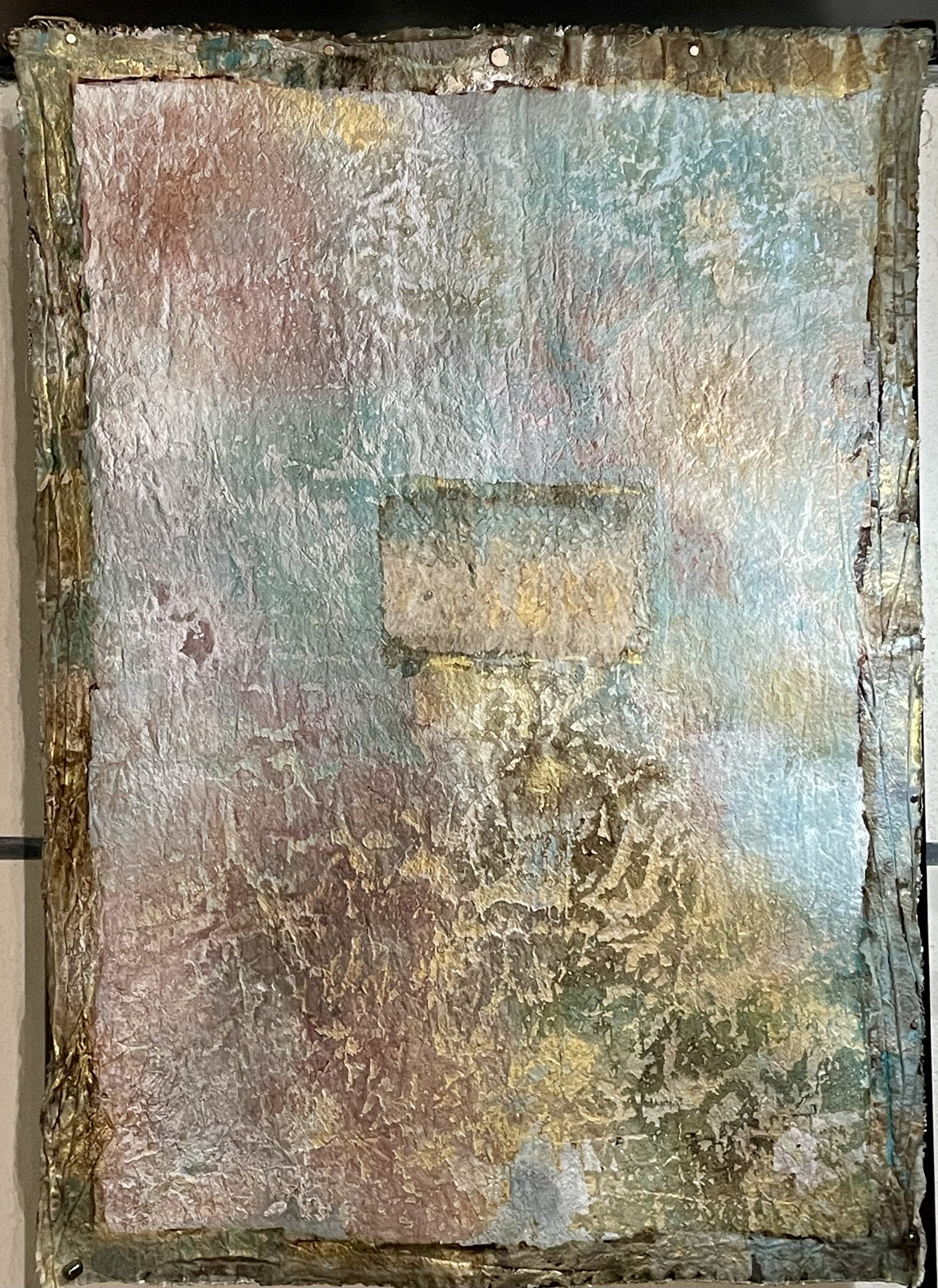 Une peinture abstraite avec des textures épaisses et des couleurs pastel telles que le rose, le bleu, le vert, le jaune et le beige, encadrée avec des bords en bois. Le style est texturé et multicolore.